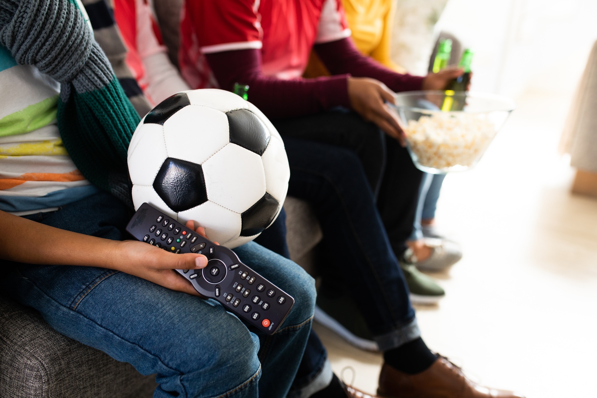 Mid section of family watching sports on TV at home