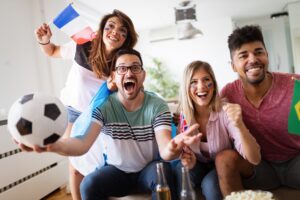 Young group of friends watching sport on television