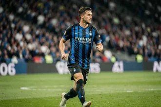 Joueur de l'Inter Milan en maillot rayé noir et bleu sur la pelouse lors d'un match de Ligue des Champions